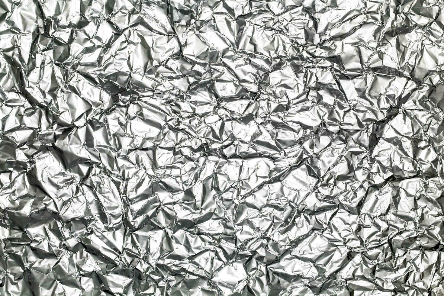 silver leaf foil background with shiny crumpled uneven surface for texture and background photo