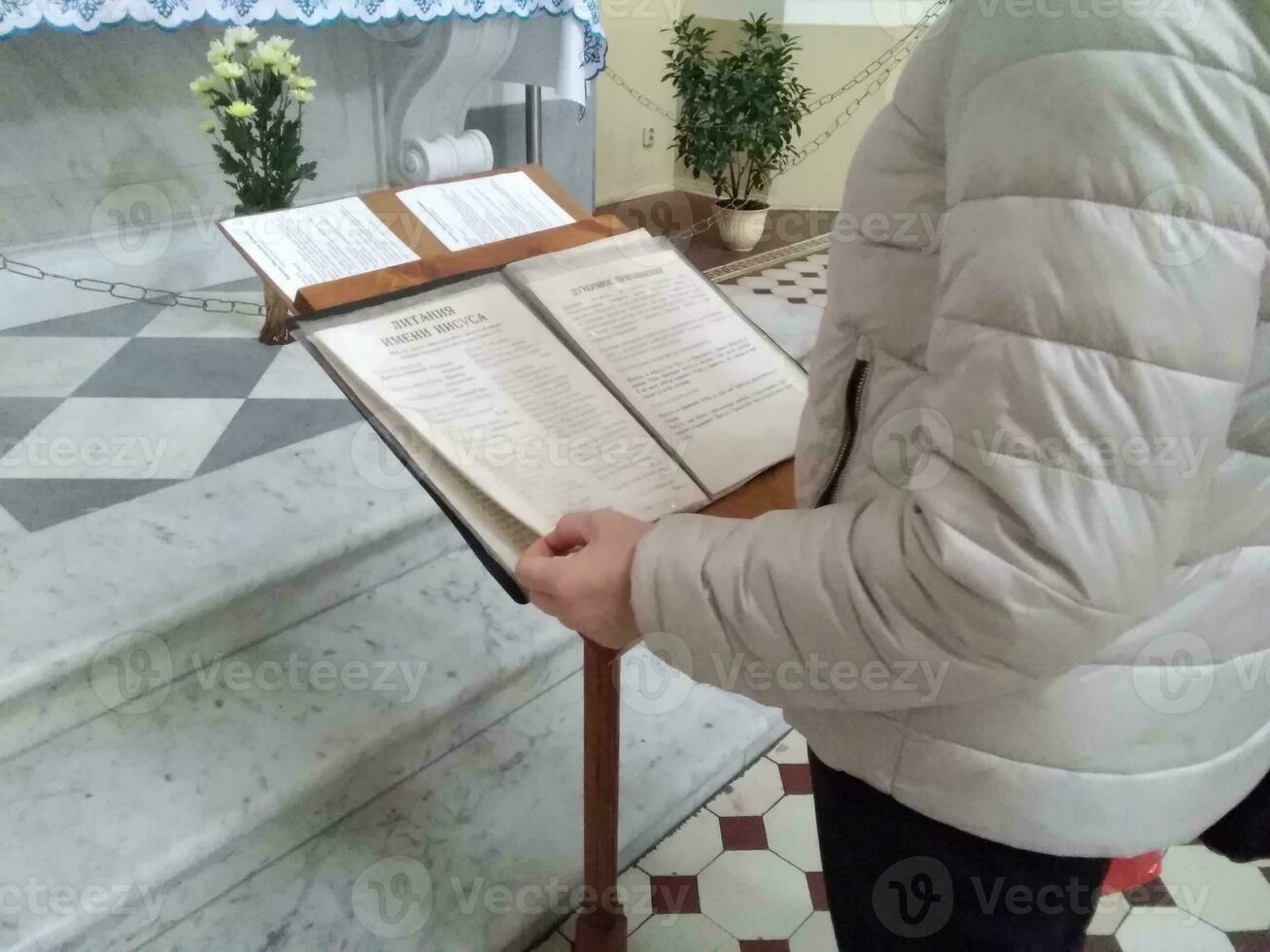 mujer Orando en el santo Biblia. participación manos en oración en un de madera mesa. oración a Dios para el crisis de cristiano vida. oración en un santo Biblia en Iglesia concepto para fe. foto