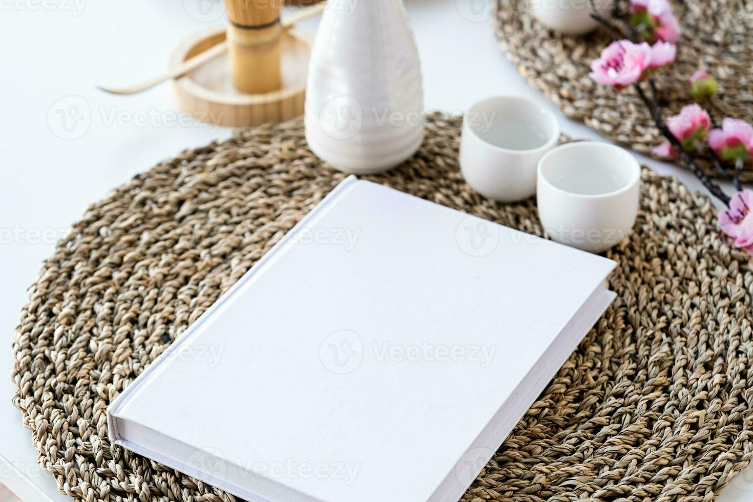 Book mockup design. Blank white book on dining table in asian style with tableware photo