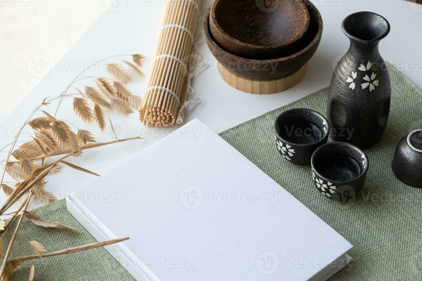 Book mockup design. Blank white book on dining table in asian style with tableware photo