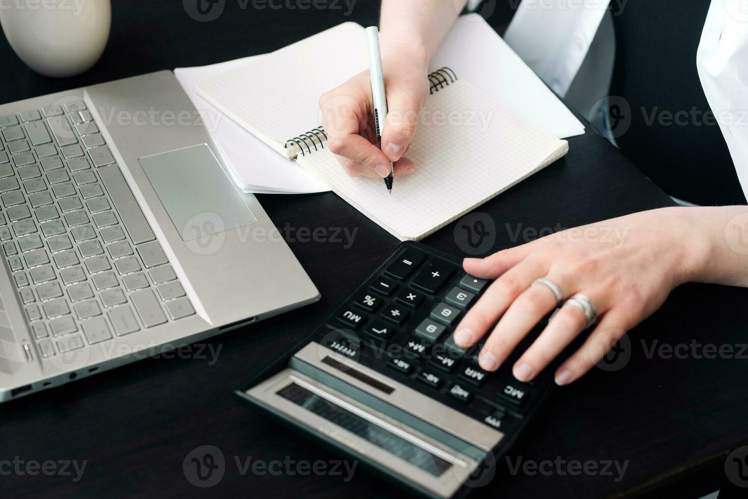 Diligent Businesswoman in Finance. Analyzing Budget, Calculating Finance Report with Calculator, Close-Up of Document. Calculating Finance Report. Woman Working in Finance and Budget photo