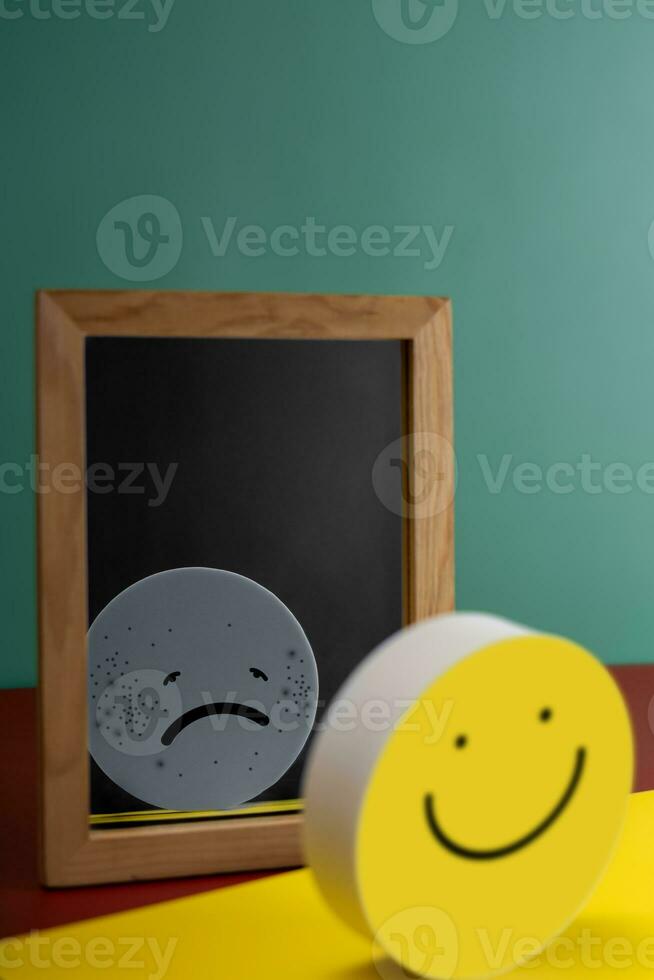 Mental Health Concept. Complexity of Deepest Mind and the Personality to Expressed Different Characteristics in Public. a Happy Face Reflects a Sad face on another side of the Mirror. Bipolar Disorder photo