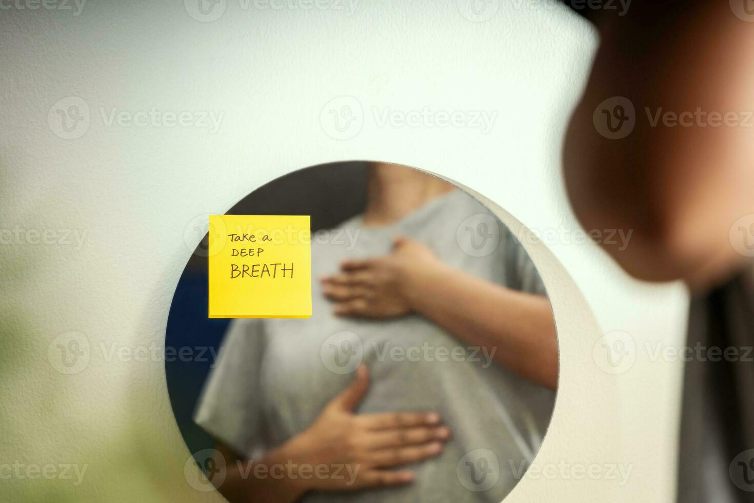 mental salud concepto. un mujer practicando profundo respiración en frente de el espejo. calma, meditación, bien siendo y sano estilos de vida foto