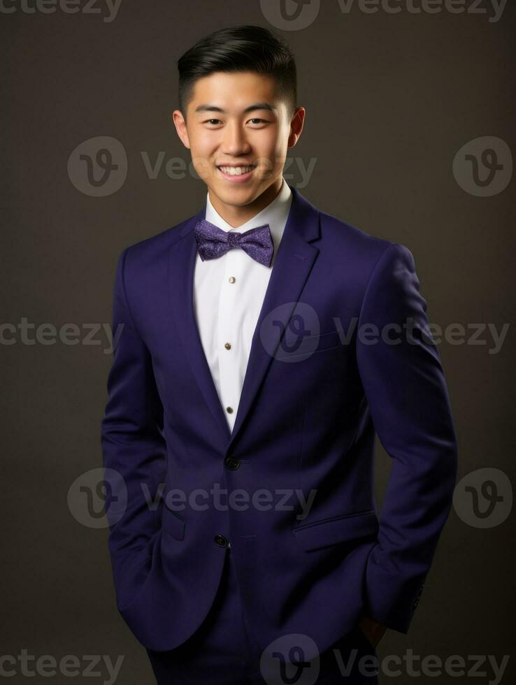 Smiling young man of Asian descent dressed in suit on gray background AI Generative photo