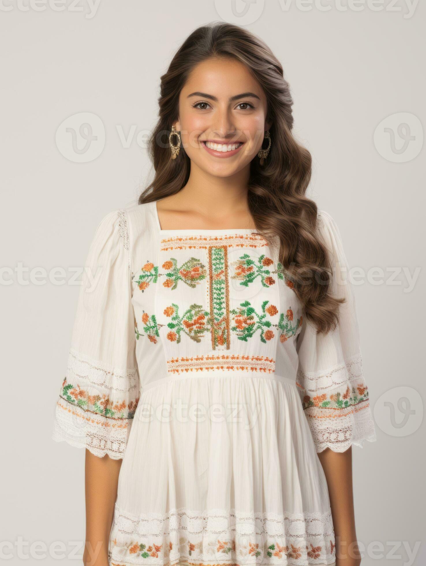 Smiling young woman of Mexican descent dressed in elegant dress on gray