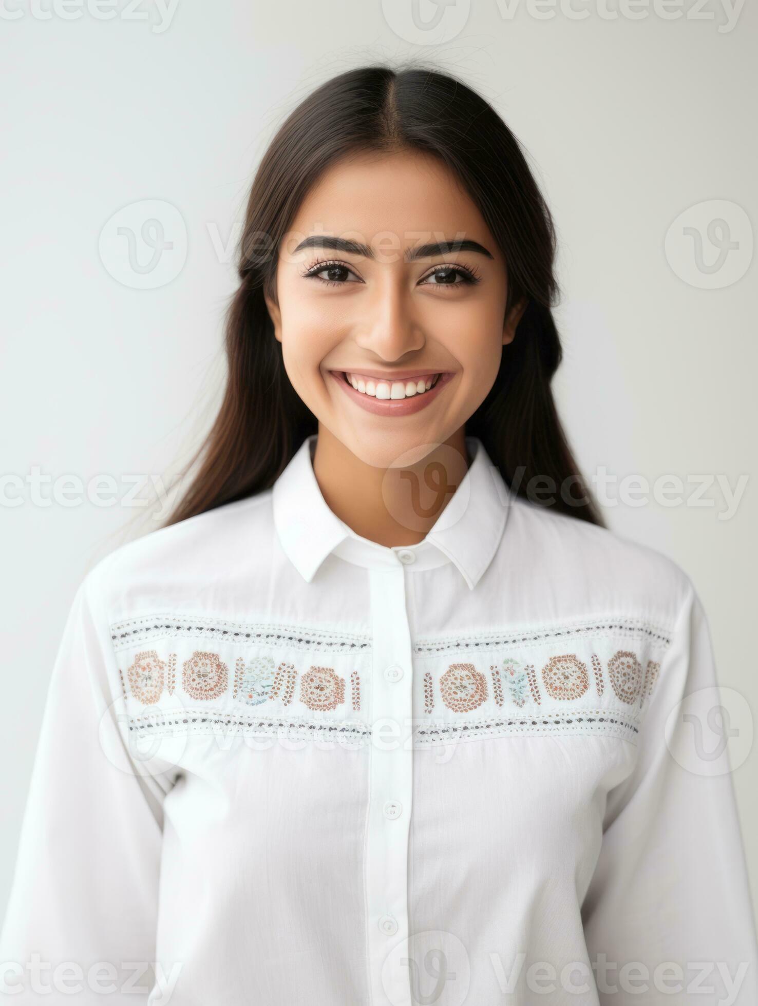 Smiling young woman of Mexican descent dressed in elegant dress on gray