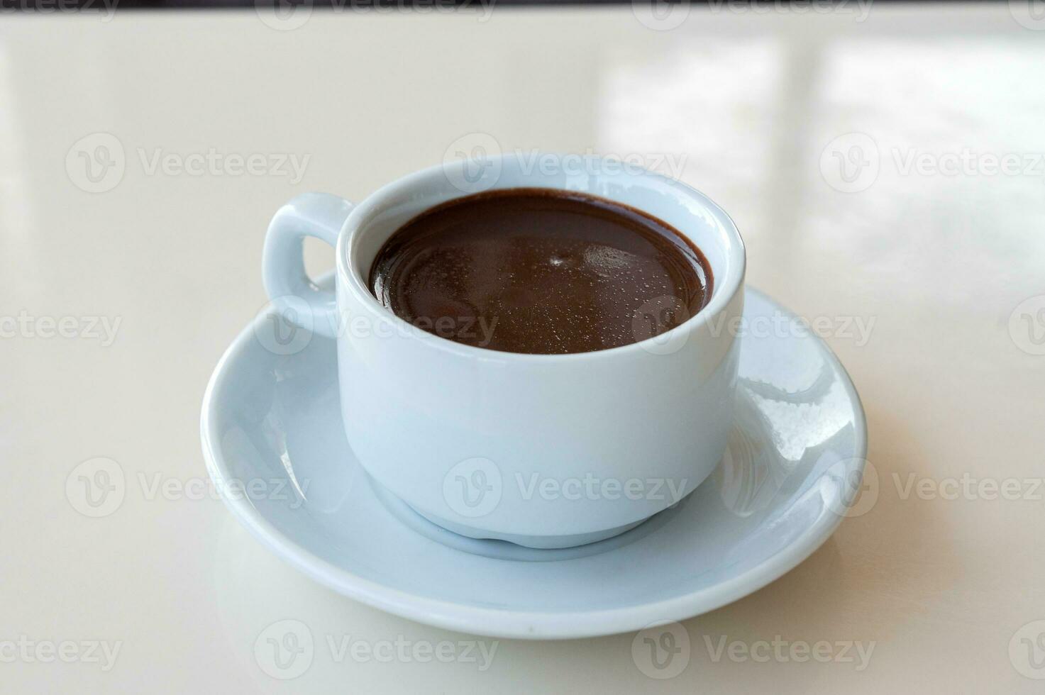 caliente amargo chocolate en un blanco jarra es en el mesa foto