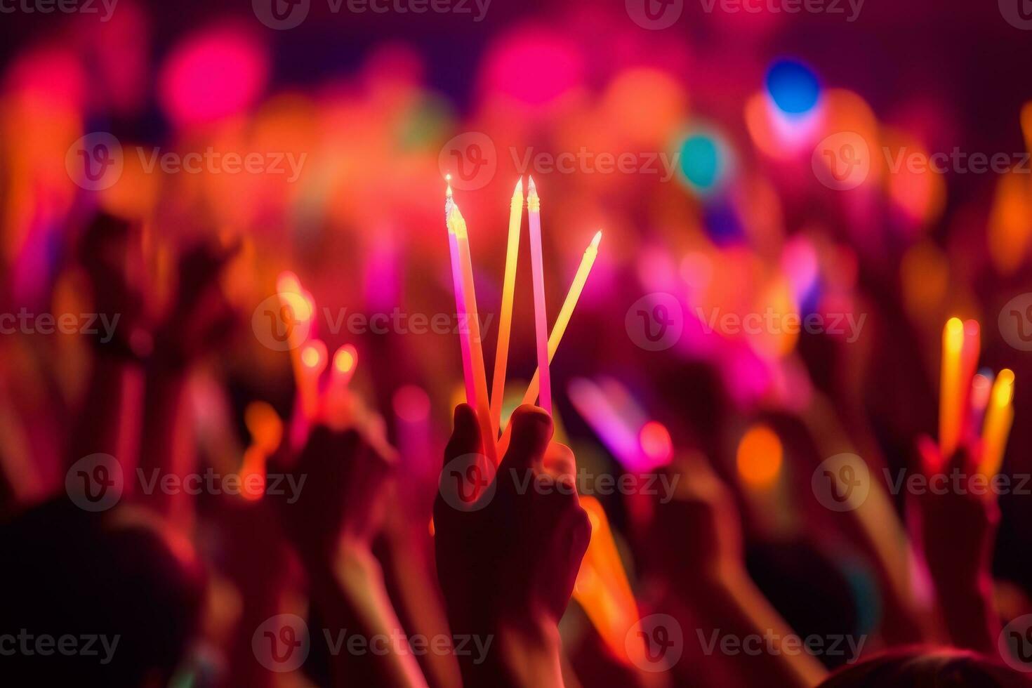 A close-up shot of hands holding glow sticks in the air at a rave party with a blurry crowd of people dancing in the background. Generative Ai photo