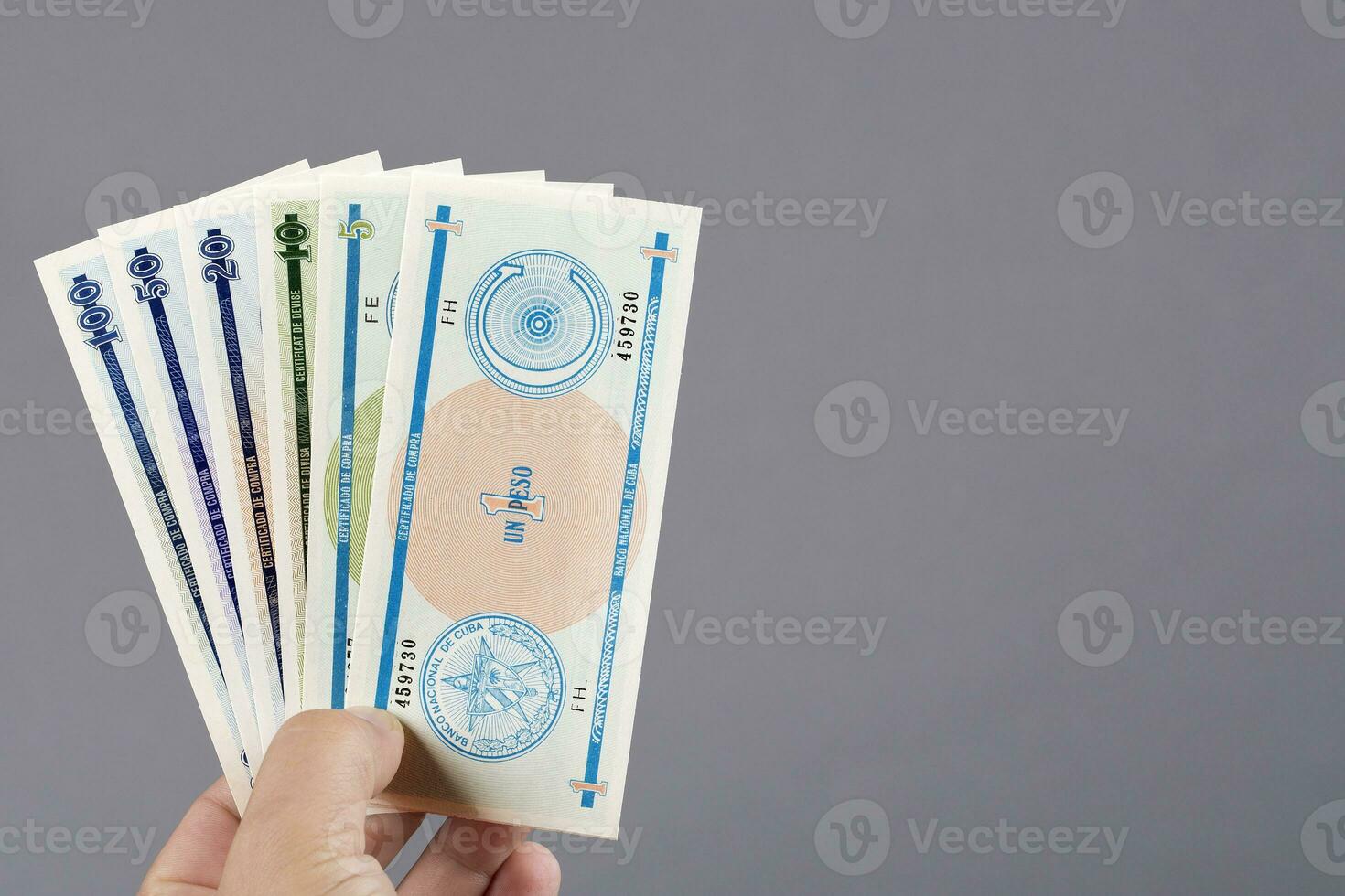 Cuban money in the hand on a gray background photo