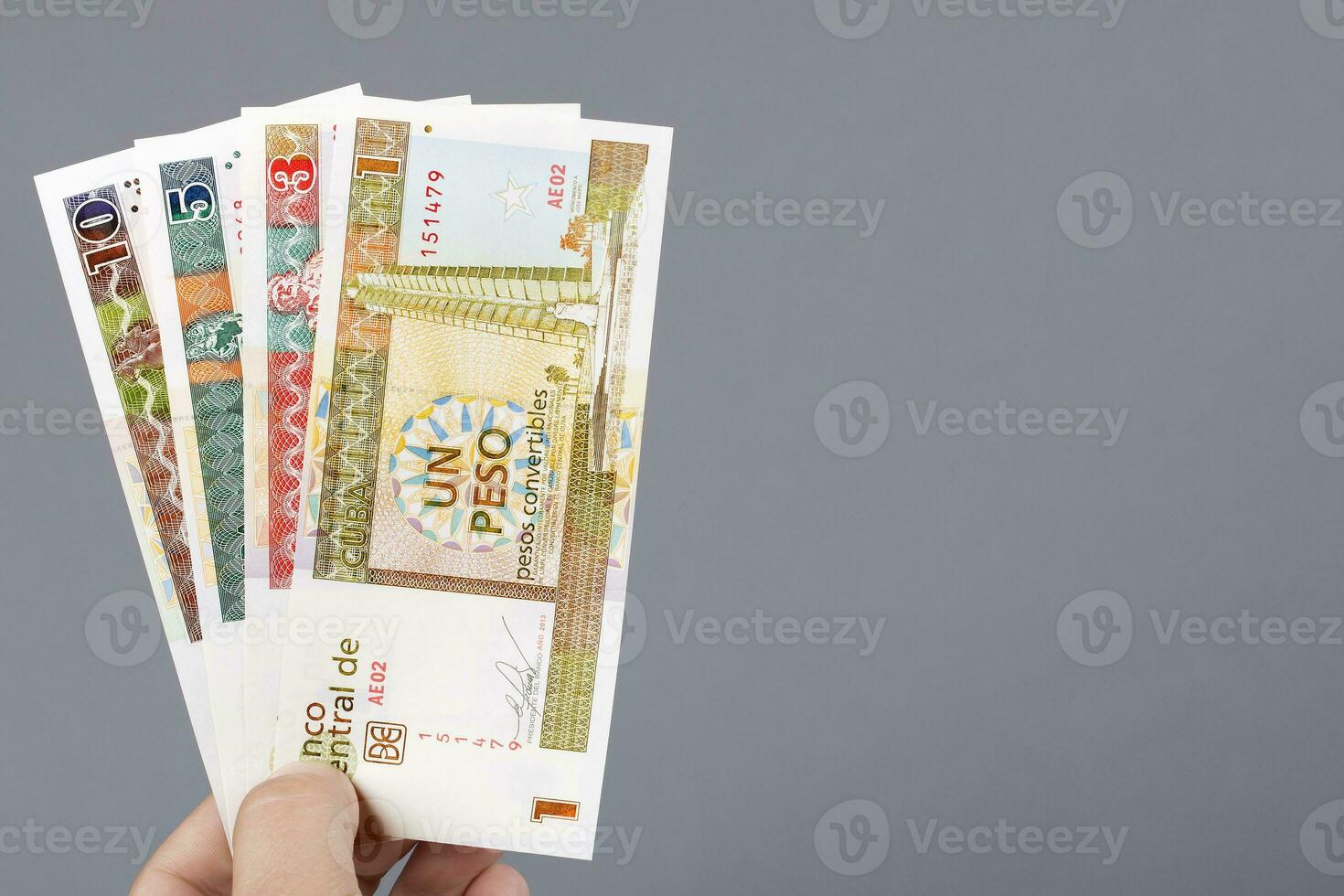 Cuban money in the hand on a gray background photo