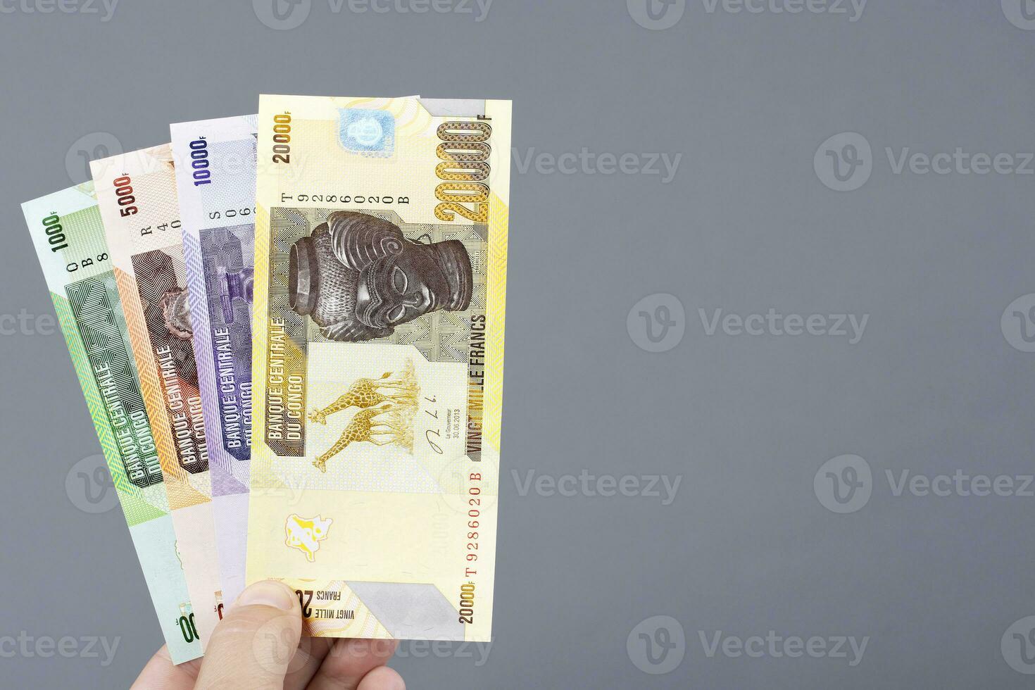 Congolese money in the hand on a gray background photo