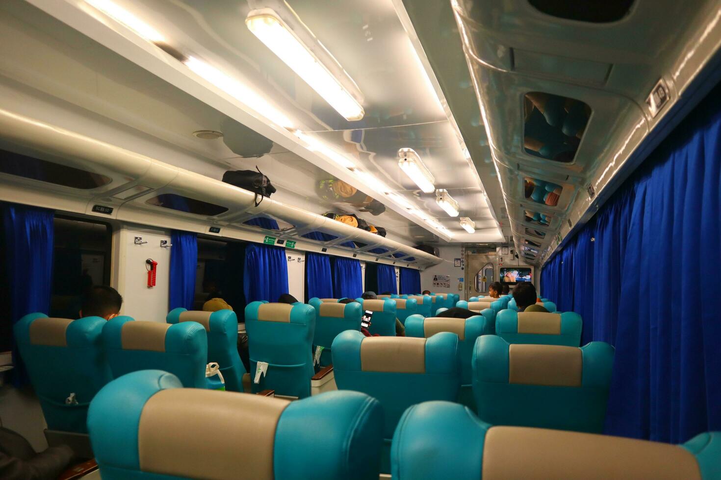 ejecutivo clase tren interior con azul asientos, reposabrazos, equipaje bastidores, monitor pantallas, aire acondicionamiento, y luces ese ampliar en el techo foto