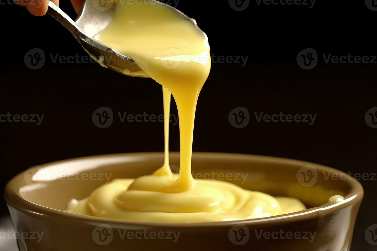 un cucharada de amarillo salsa siendo vertido dentro un cuenco foto