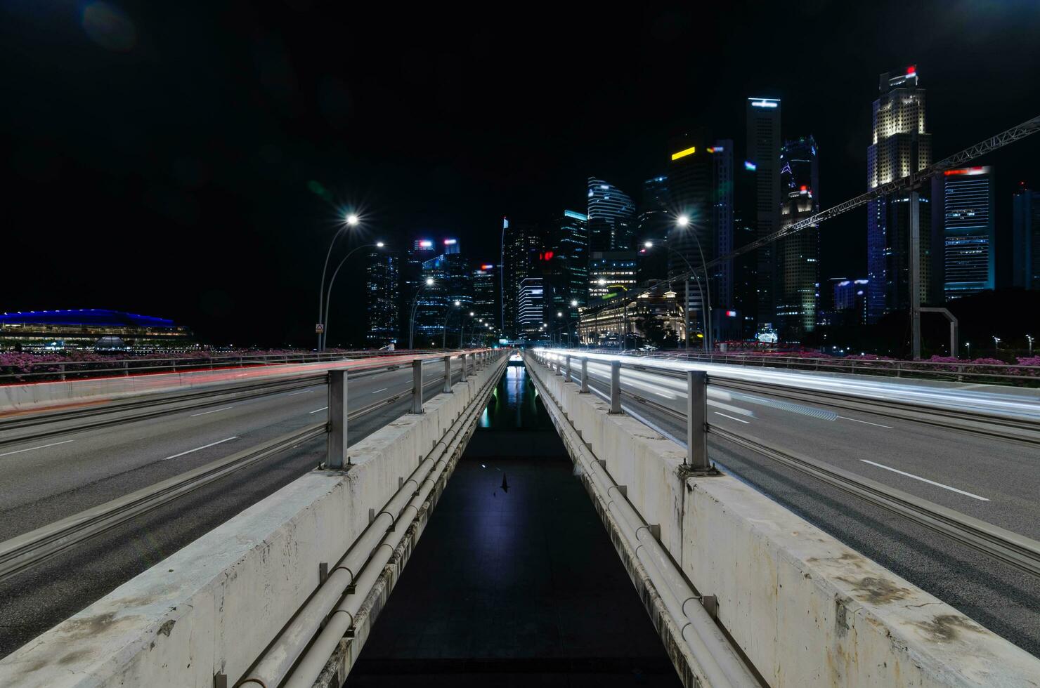 express highway leads to singapore city down town city central district in night time, highway bridge with many skyscraper financial buildings in background during rush hour photo