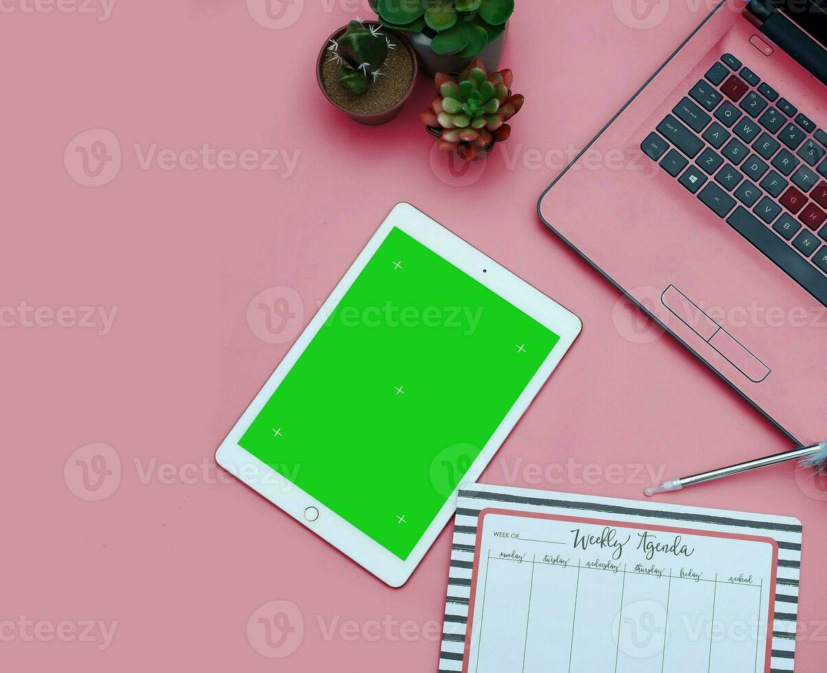 Top view of a streamlined work-from-home workspace with essential gadgets and a green screen setup. This minimalist arrangement is perfect for efficient remote work, virtual meetings, creatives. photo
