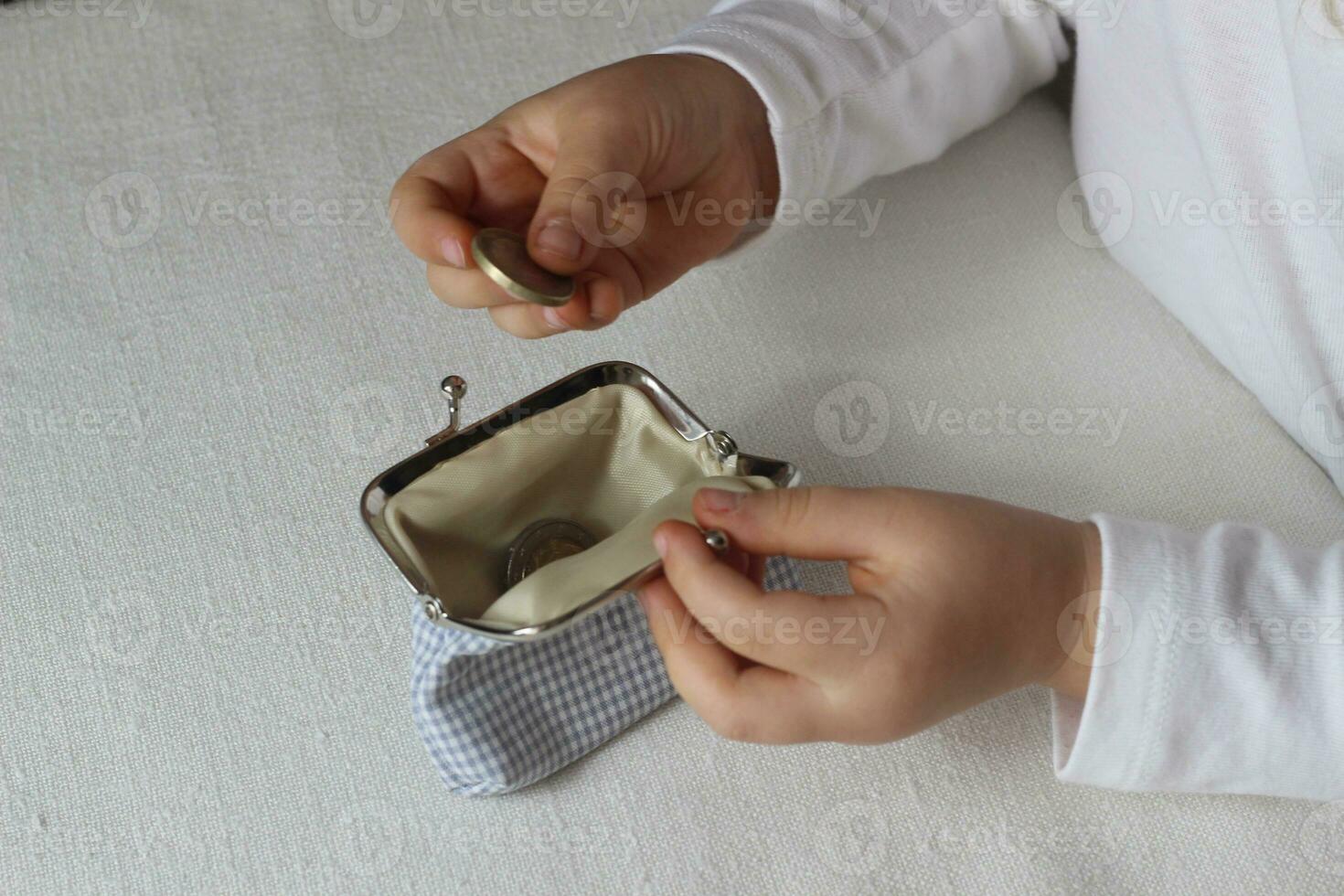 Kids hands put coins in a wallet,toddler girl with money and pusre in hand.Learning financial responsibility and planning savings.Financial education for child,financial support.Investing in children photo