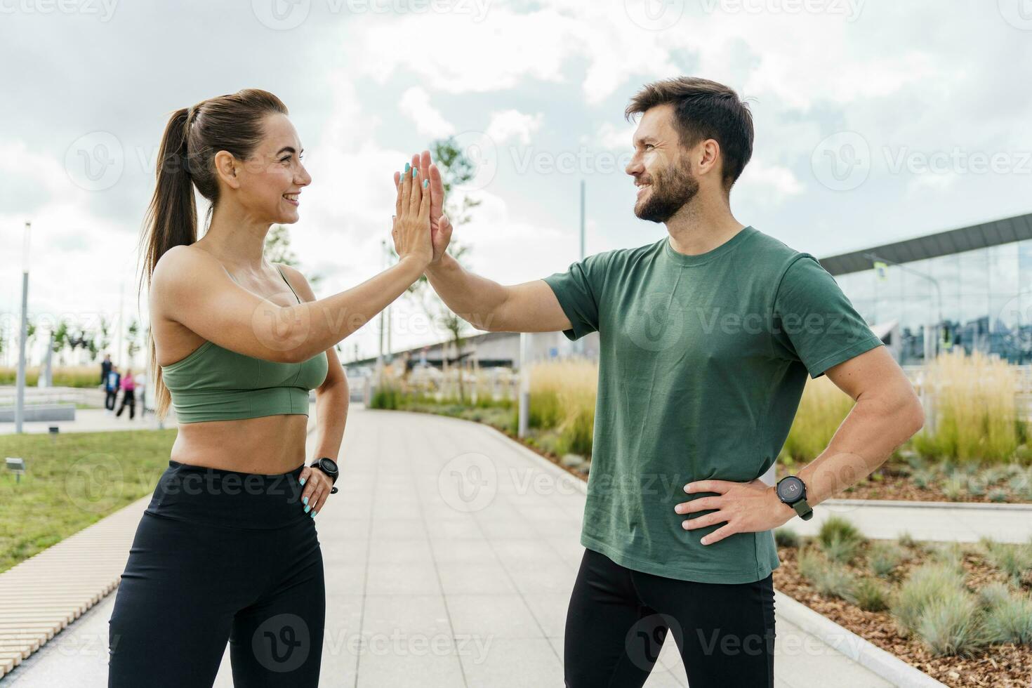 People in sportswear together, physical education and sports. Athletic man and woman train in fitness and running. Using smart watches and a fitness app.    Team exercises of a young couple. photo