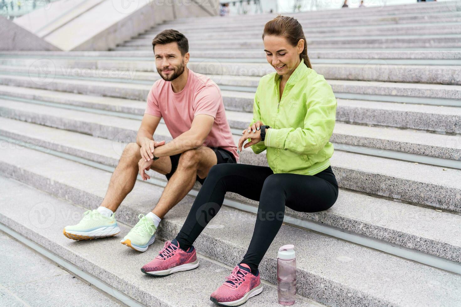 Using smart watches and a fitness app.  Male and female athletes train in fitness and running.  Team exercises of a young couple. People in sportswear together, physical education and sports. photo
