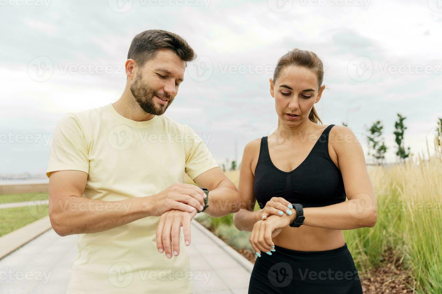Use a sports watch and a cardio app. Athletes exercise for health. Happy people jogging together. Runners partners workout in fitness clothes and running shoes. photo