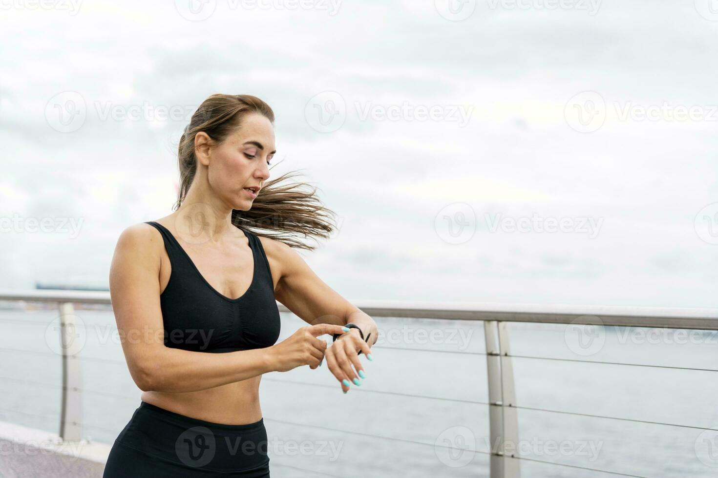 Runner woman running on beach with watch and sports bra top. Beautiful fit  female fitness model training and working out outside in summer at part of  healthy lifestyle Stock Photo