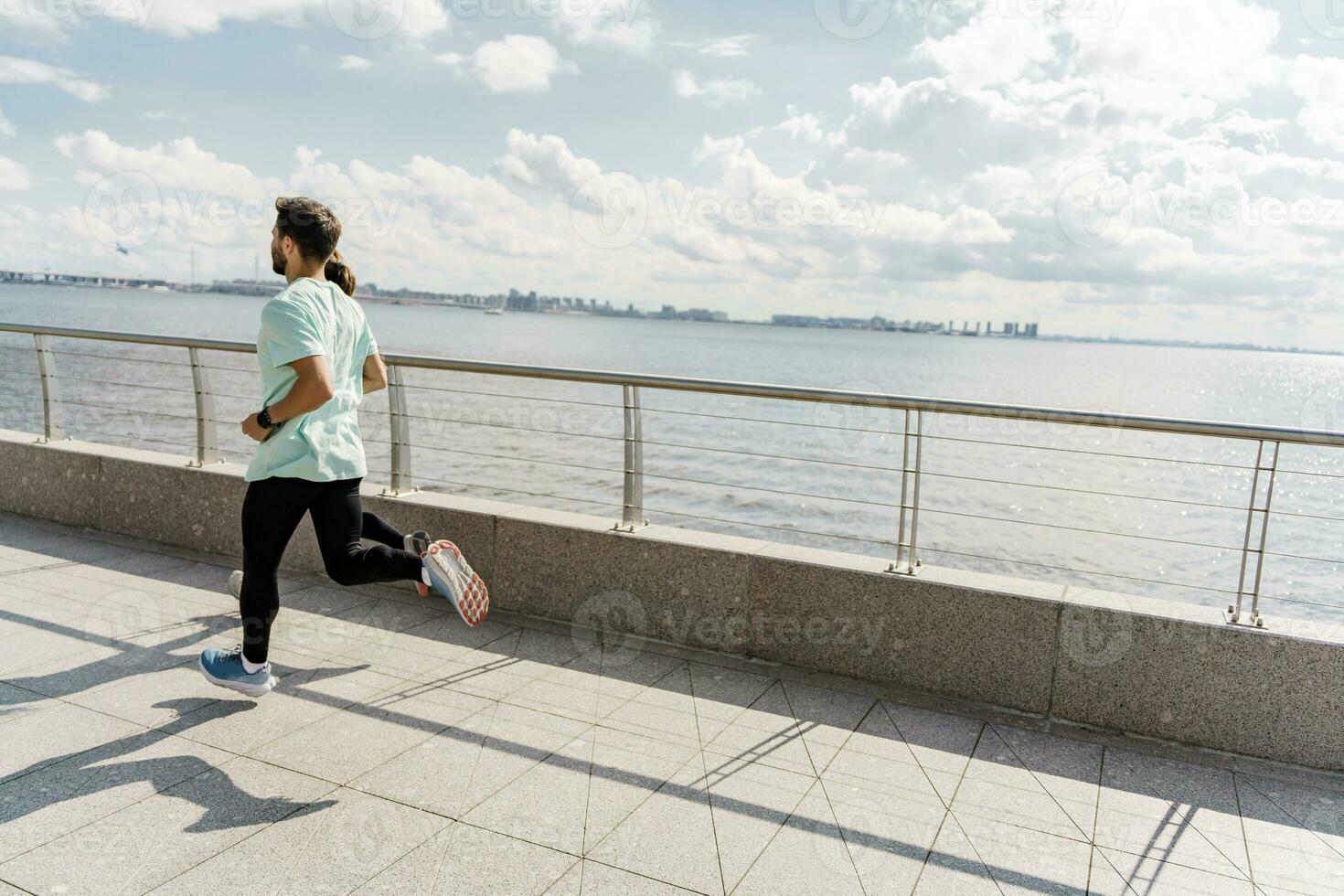 Fitness trainer workout running fitness outdoors. A person uses a fitness watch and a running app. A man in sportswear for sports. photo