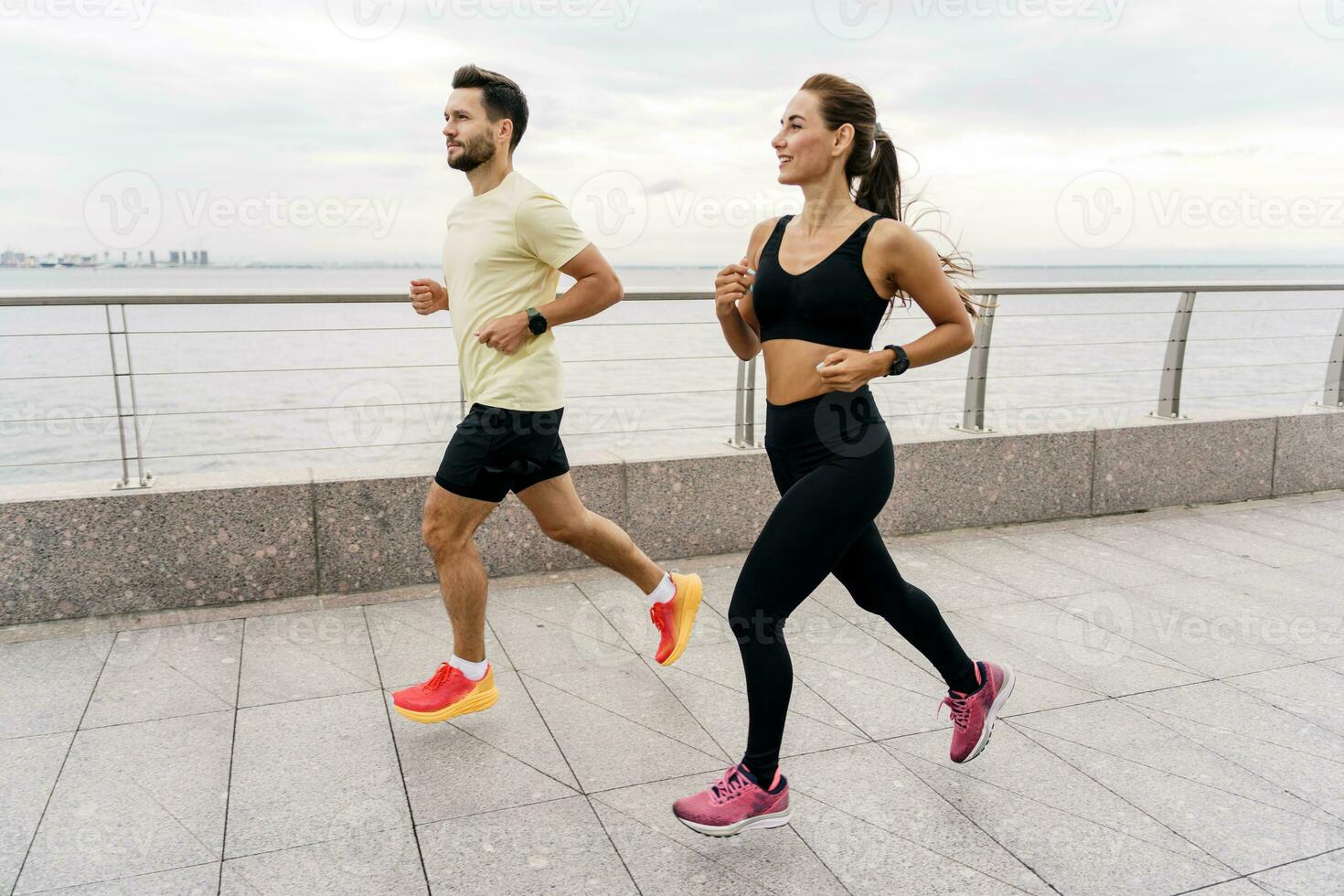 A man and a woman training together. Friends outdoor exercise physical activity for the body. People in fitness clothes and sneakers are doing sports. Use a fitness watch. photo