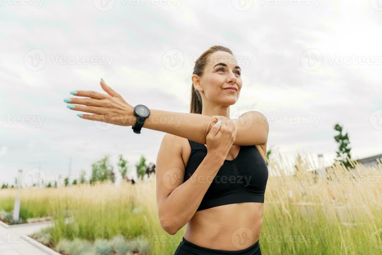 Fitness trainer workout running fitness outdoors. A person uses a fitness watch and a running app. A woman in sportswear for sports. photo