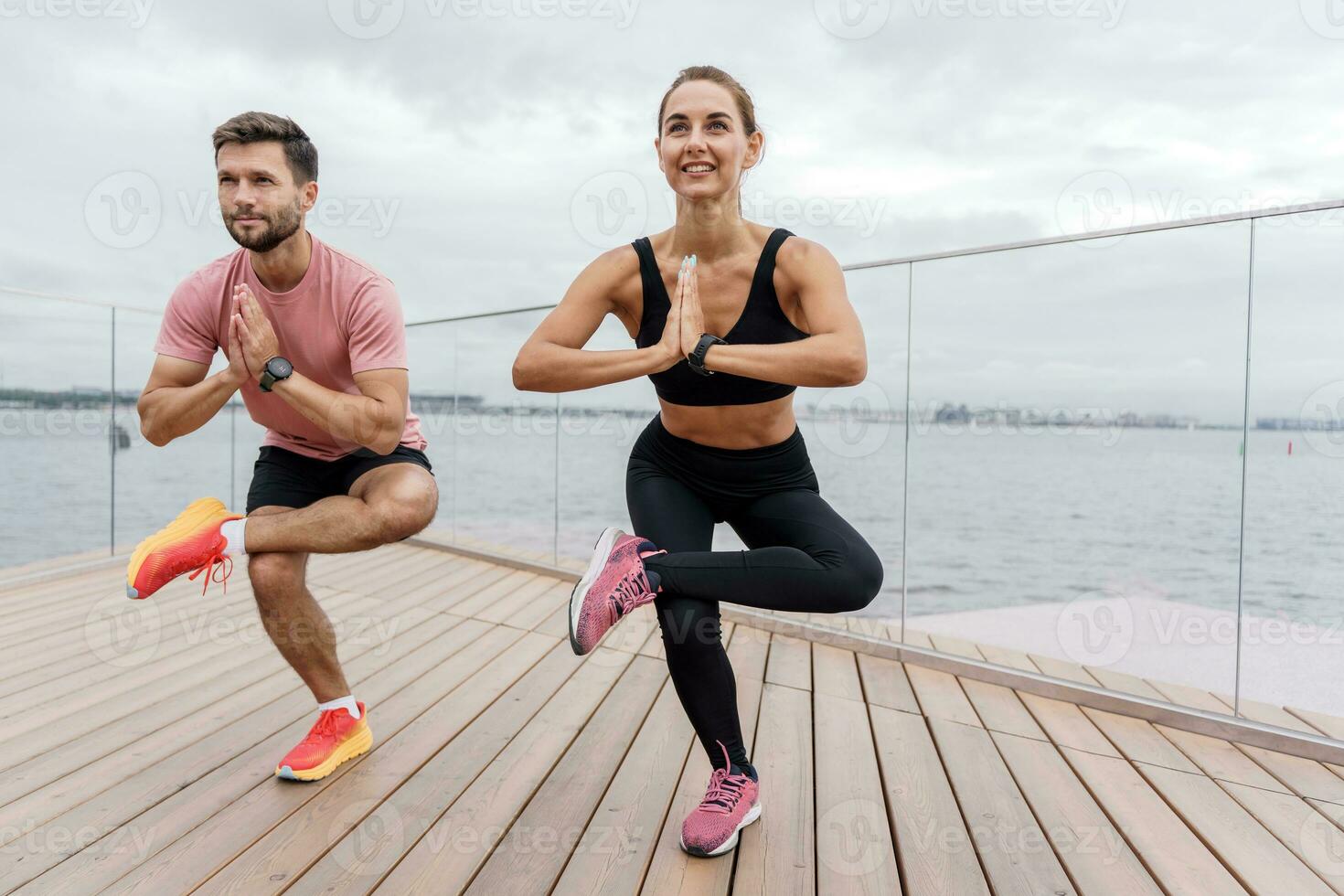 The trainer and the client teach fitness exercises. Confident strong people in sportswear. A person uses a fitness watch. A man and a woman train together. photo