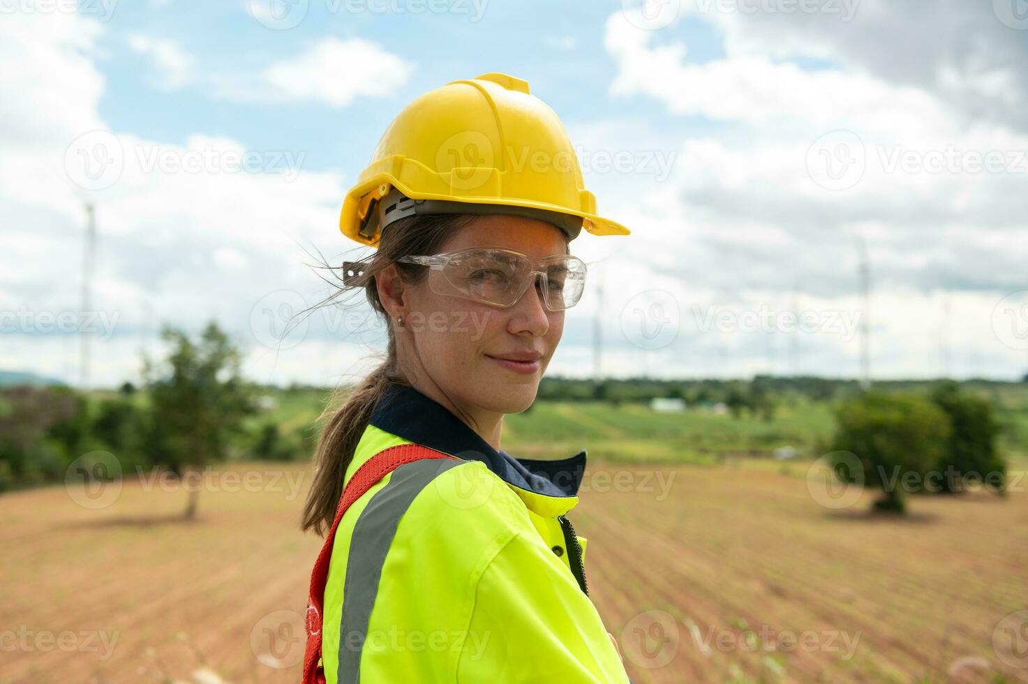 Portrait of smart engineer with protective helmet at electrical turbines field photo