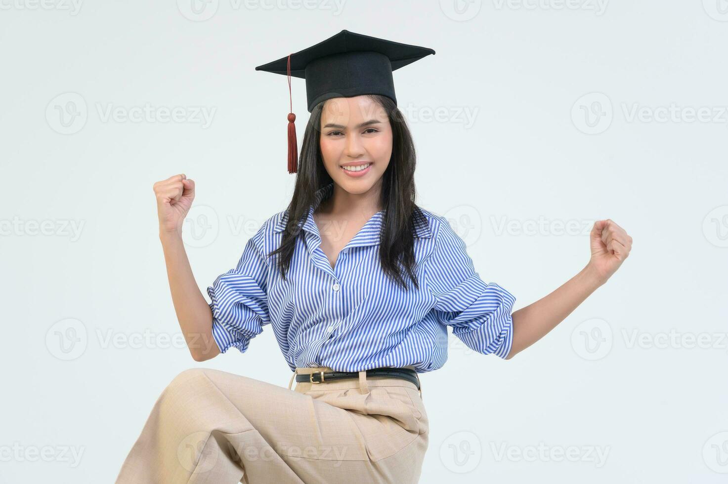 Portrait of happy Beautiful woman in graduation gown over white background photo