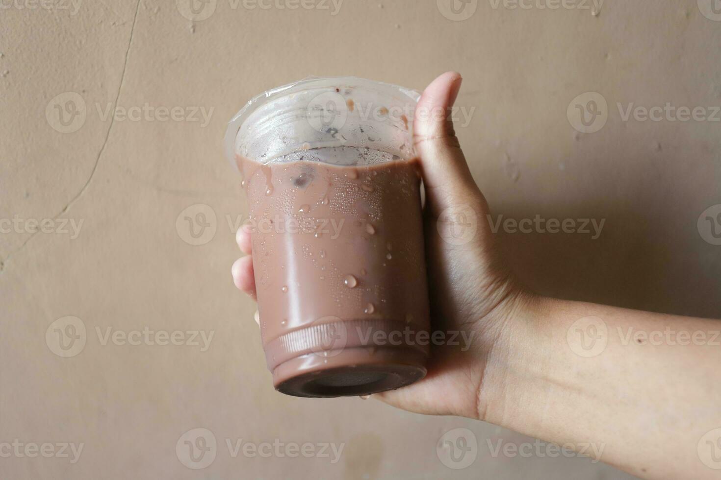 un mano participación un botella de con hielo chocolate foto