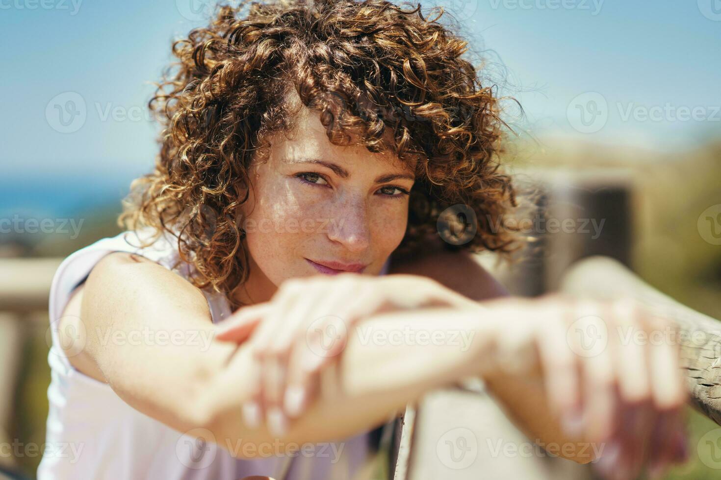 Young woman with curly hair and blurred hands photo
