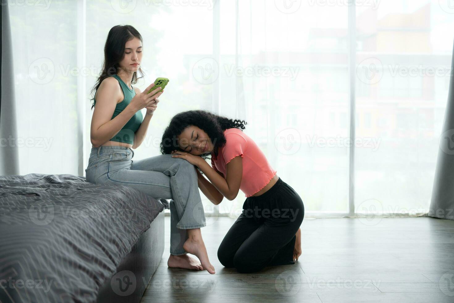 Young woman using smartphone in living room at home with a friend who is looking forward to asking for reconciliation, The concept of love LGBT photo