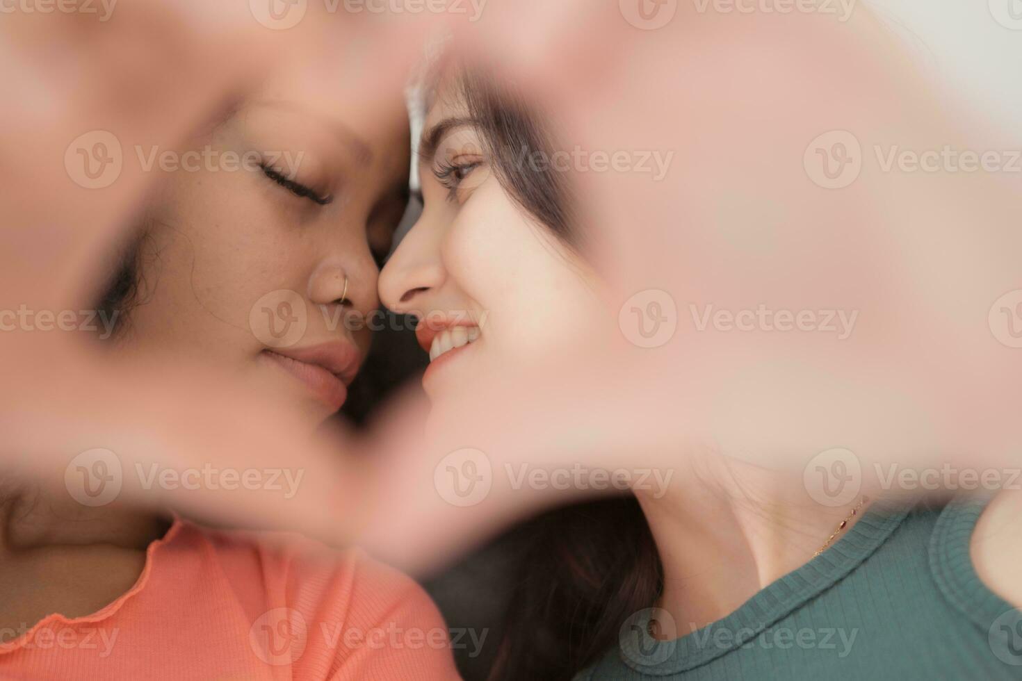 Young African American woman kissing her friend on the lips. photo