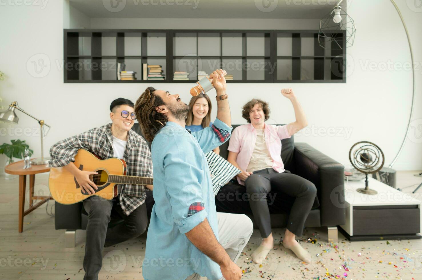 Multiethnic group of friends having fun playing guitar and singing together at home photo