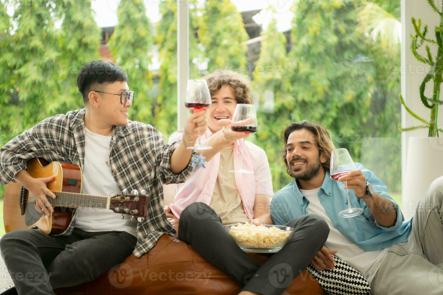 Multiethnic group of friends having fun playing guitar and singing together at home photo