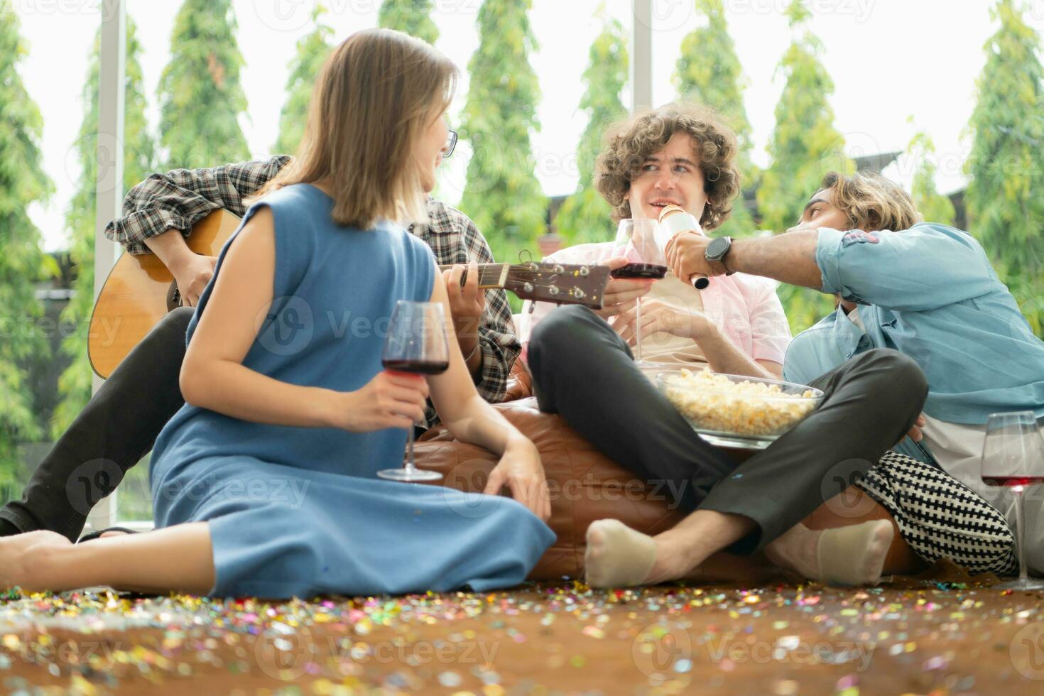 Multiethnic group of friends having fun playing guitar and singing together at home photo
