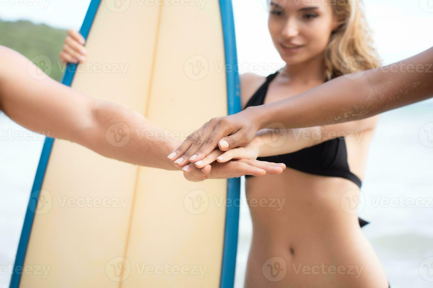 Portrait of smiling young woman in bikini with surfboard at beach photo