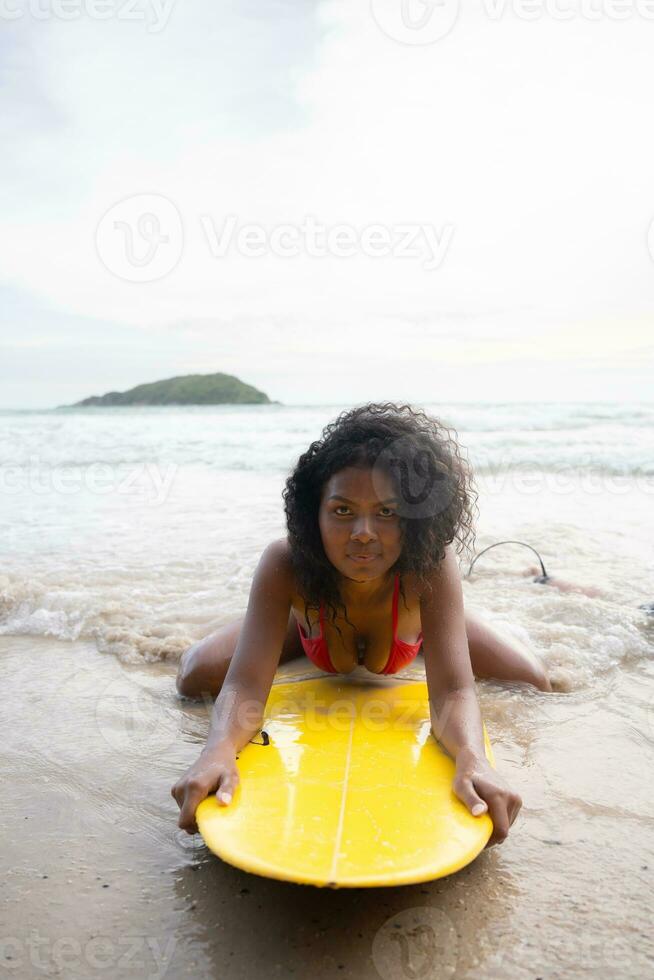 Surfer girl with her surfboard on the beach. photo