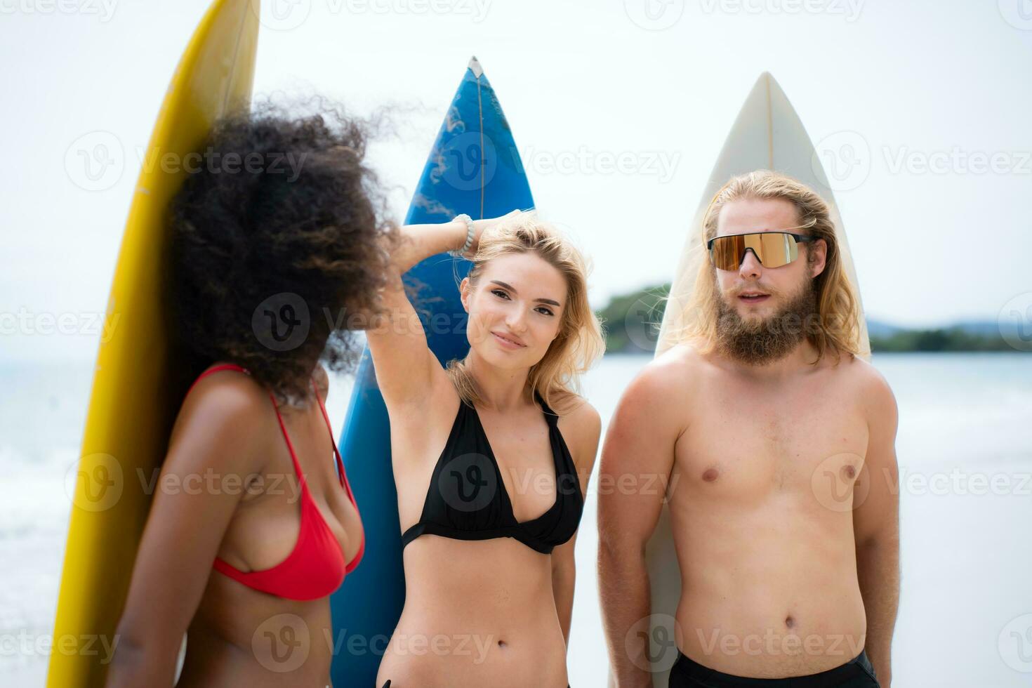 Portrait of smiling young woman in bikini with surfboard at beach photo