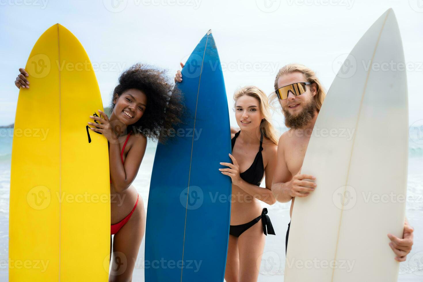 Portrait of smiling young woman in bikini with surfboard at beach photo