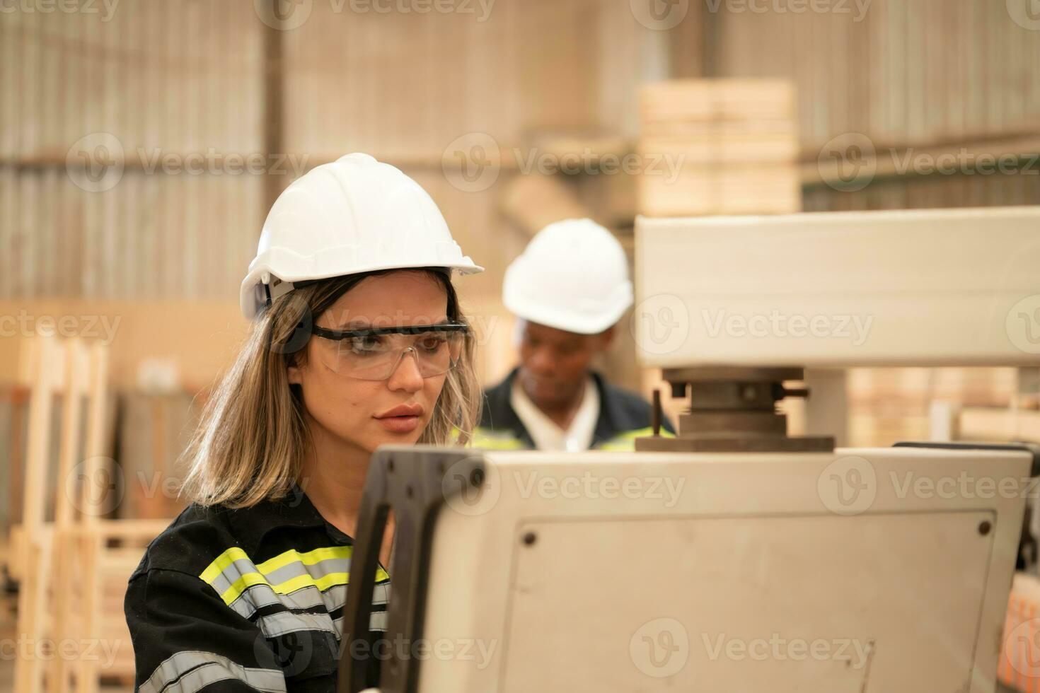 Both workers work in a woodworking factory, Working with wood sawing and cutting machines to produce wooden sheets for making pallets photo