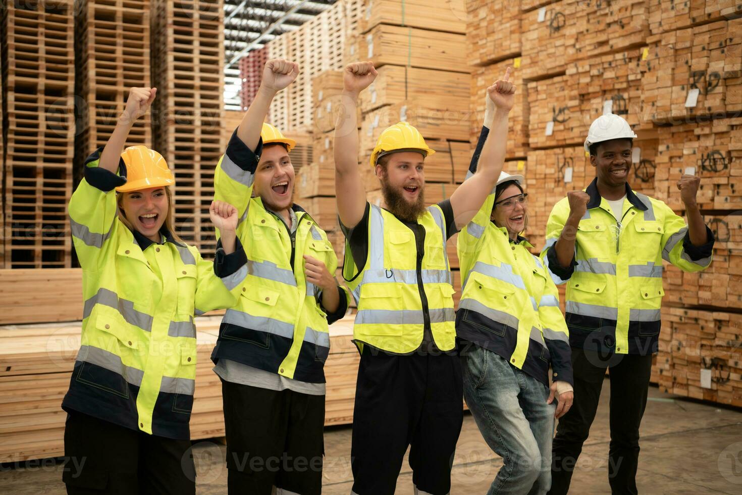 Group of workers in a large timber factory, Have fun by raising your arms after completing the day's work. photo