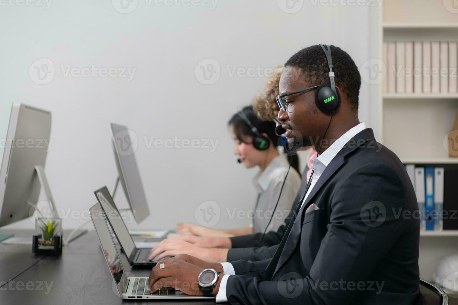 Group of business people wearing headset working actively in office. Call center, telemarketing, customer support agent provide service on telephone video conference call. photo