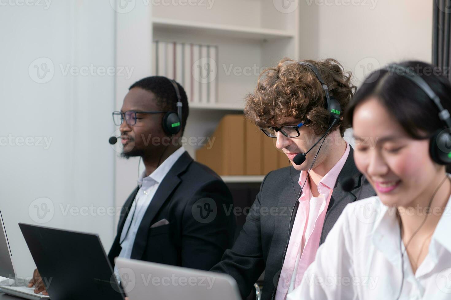 Group of business people wearing headset working actively in office. Call center, telemarketing, customer support agent provide service on telephone video conference call. photo