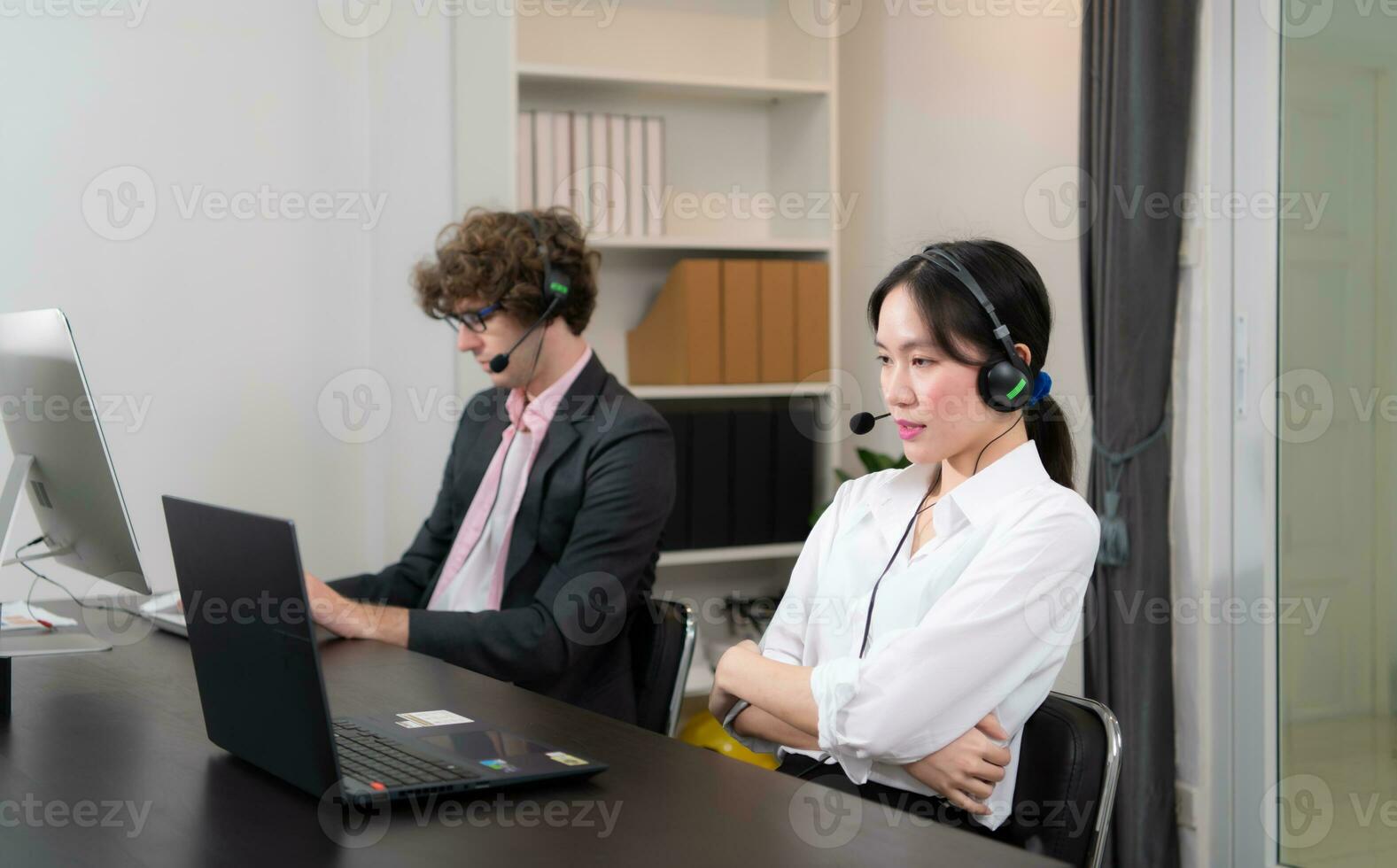 Group of business people wearing headset working actively in office. Call center, telemarketing, customer support agent provide service on telephone video conference call. photo