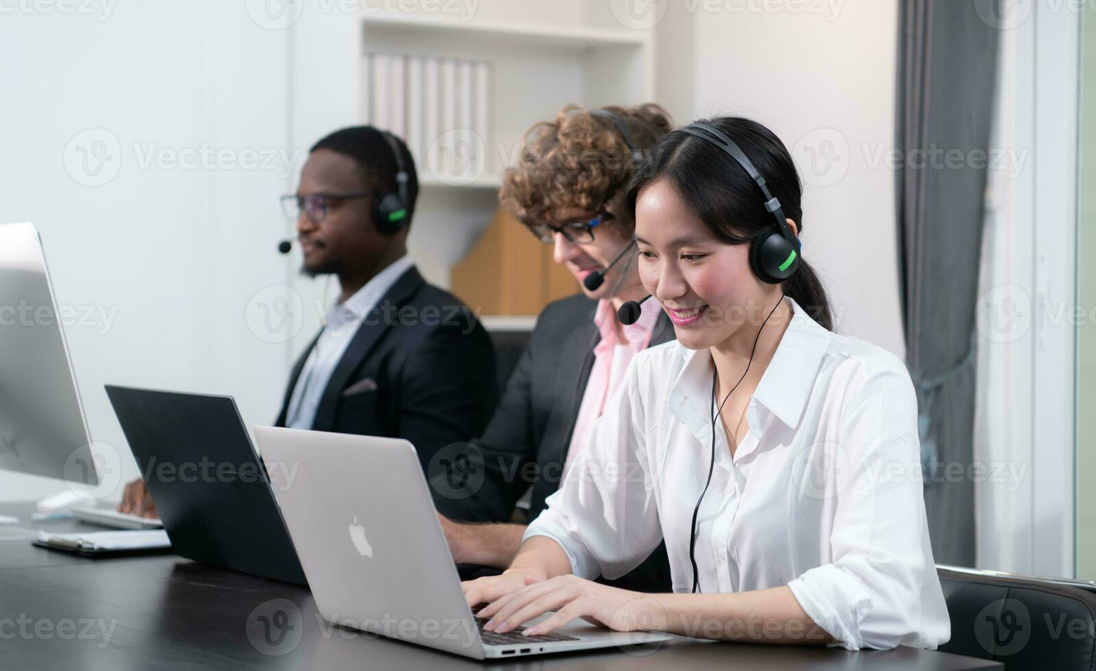 Group of business people wearing headset working actively in office. Call center, telemarketing, customer support agent provide service on telephone video conference call. photo