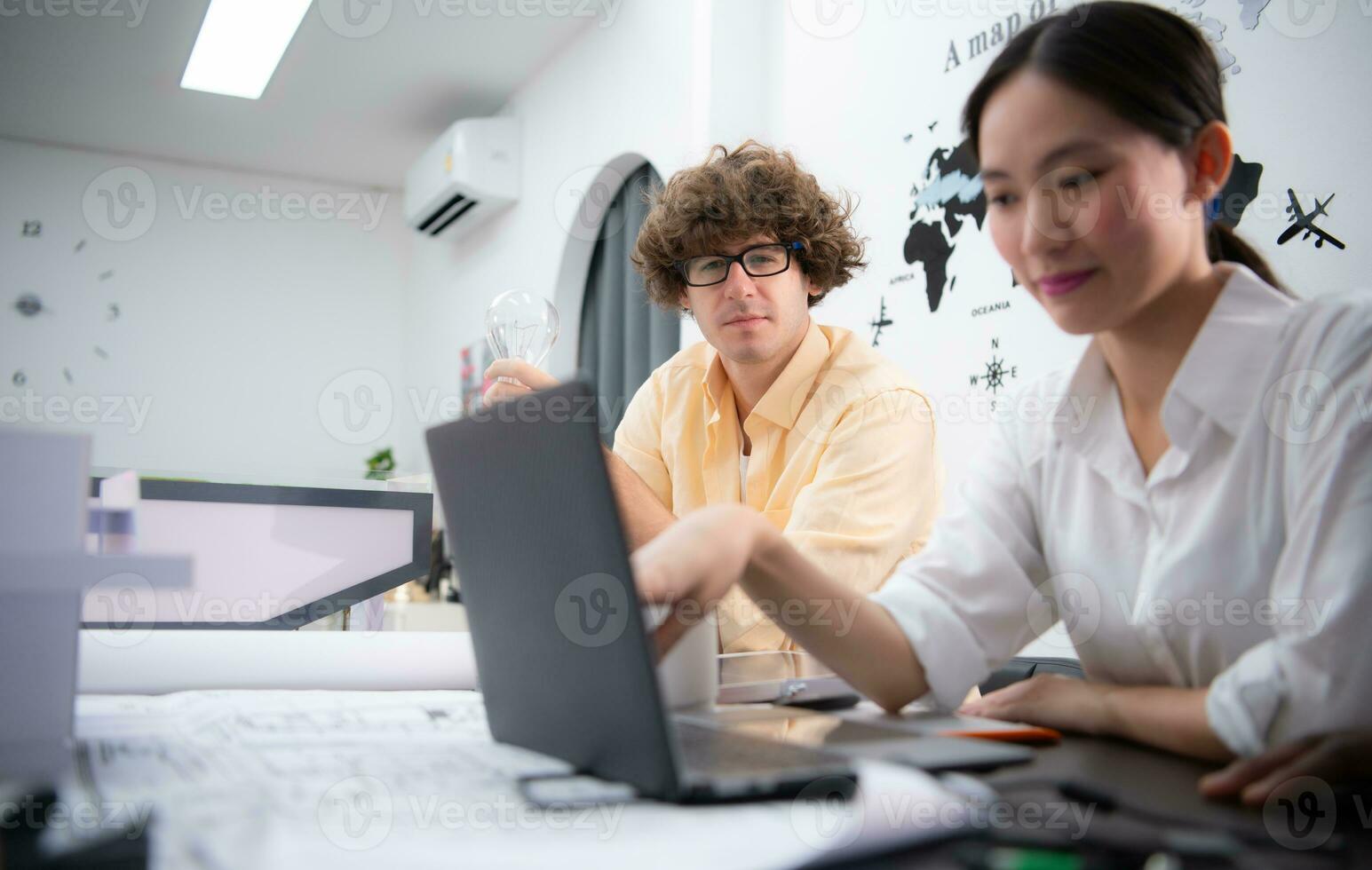 Multiethnic team of architects and designers are meeting new project, He carries a light bulb that should not be used in buildings because it is not energy efficient and not earth-friendly. photo