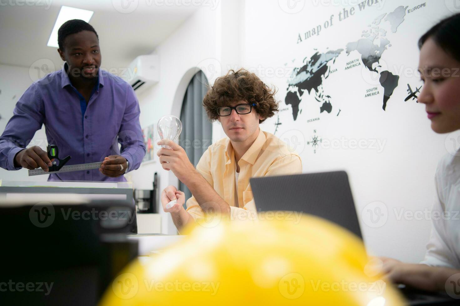 Multiethnic team of architects and designers are meeting new project, He carries a light bulb that should not be used in buildings because it is not energy efficient and not earth-friendly. photo