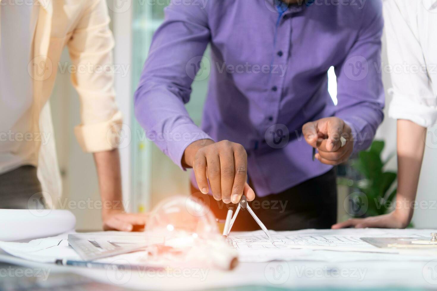 Group of architect and designer is designing a green home building that takes advantage of natural energy such as wind and sunlight. photo